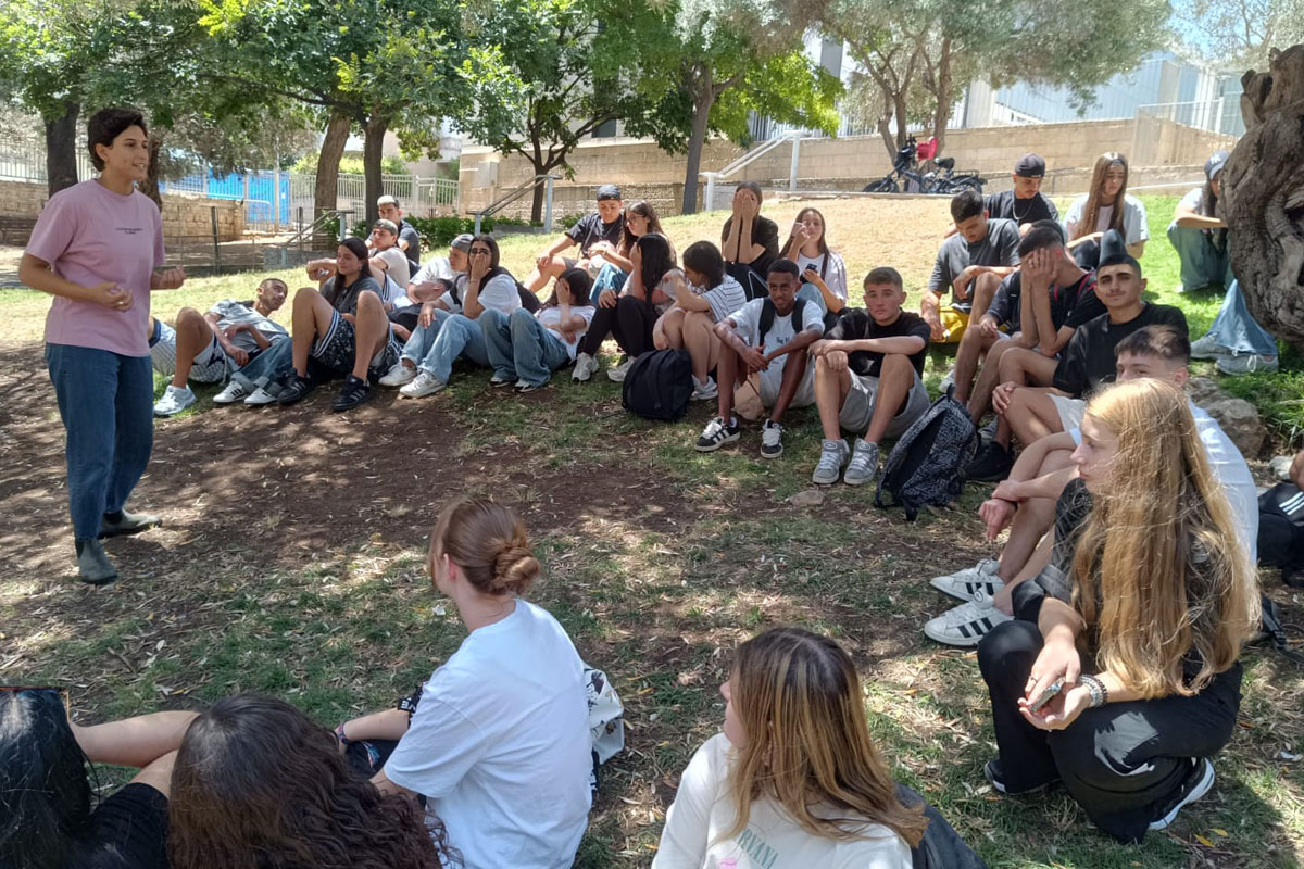 קבוצת צעירים משתתפת בשיחה עם יוזם חברתי מקומי על קידום סובלנות בעיר חיפה